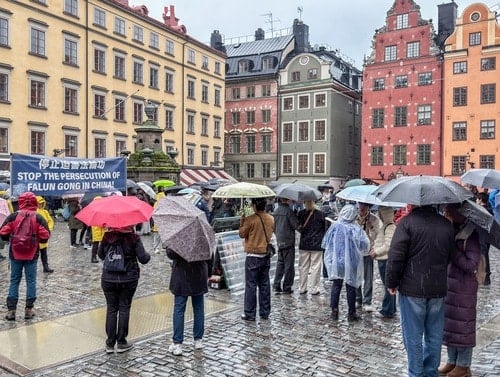Turister framför Nobelprismuseet i Stockholm får lära sig om Falun Gong.